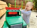 A little cute boy of one and a half years plays with toy car at the playground. Adorable toddler playing with cars and toys Royalty Free Stock Photo