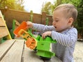 A little cute boy of one and a half years plays with toy car at the playground. Adorable toddler playing with cars and toys Royalty Free Stock Photo