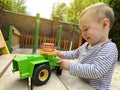 A little cute boy of one and a half years plays with toy car at the playground. Adorable toddler playing with cars and toys Royalty Free Stock Photo