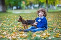 Little cute boy playing with his dog in autumn park Royalty Free Stock Photo