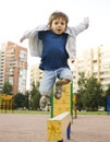 Little cute boy playing on playground, hanging on gymnastic ring Royalty Free Stock Photo