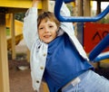 Little cute boy playing on playground, hanging on gymnastic ring Royalty Free Stock Photo