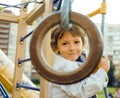 Little cute boy playing on playground, hanging on gymnastic ring Royalty Free Stock Photo