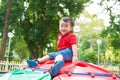 Little cute boy playing on playground, hanging on Royalty Free Stock Photo