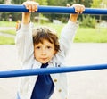 Little cute boy playing on playground, hanging on gymnastic ring Royalty Free Stock Photo