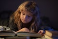 A little cute boy reading a book lying on the bed. Kids development of the imagination. Royalty Free Stock Photo