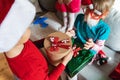 Little cute boy in red Christmas santa claus hat gives gift to sister, friend. Boxes with bows.Playing kids, congratulations, Royalty Free Stock Photo