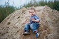 Little cute boy riding a roller coaster of sand on the bottom. Memories childhood and carefree