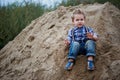 Little cute boy riding a roller coaster of sand on the bottom. Memories childhood and carefree