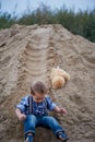 Little cute boy riding a roller coaster of sand on the bottom. Memories childhood and carefree