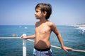 Little cute boy on sea pier enjoying summer Royalty Free Stock Photo