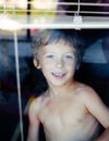 Little cute boy throught window Royalty Free Stock Photo