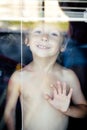 Little cute boy throught window Royalty Free Stock Photo