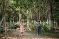 A little cute boy in vintage clothes and a little beautiful girl in a retro dress are walking in the woods and taking pictures. Royalty Free Stock Photo