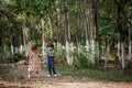 A little cute boy in vintage clothes and a little beautiful girl in a retro dress are walking in the woods and taking pictures. Royalty Free Stock Photo