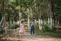 A little cute boy in vintage clothes and a little beautiful girl in a retro dress are walking in the woods and taking pictures. Royalty Free Stock Photo