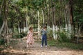 A little cute boy in vintage clothes and a little beautiful girl in a retro dress are walking in the woods and taking pictures. Royalty Free Stock Photo