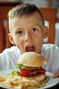 little cute boy 6 years old with hamburger and french fries maki Royalty Free Stock Photo