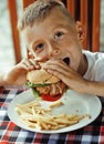 Little cute boy 6 years old with hamburger and Royalty Free Stock Photo