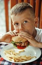 Little cute boy 6 years old with hamburger and Royalty Free Stock Photo