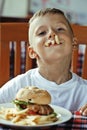 Little cute boy 6 years old with hamburger and Royalty Free Stock Photo