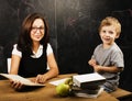 Little cute boy with young teacher in classroom studying at blackboard smiling, lifestyle people concept Royalty Free Stock Photo