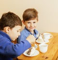 Little cute boys eating dessert on wooden kitchen. home interior Royalty Free Stock Photo