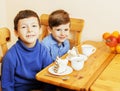 Little cute boys eating dessert on wooden kitchen. home interior Royalty Free Stock Photo