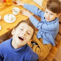 Little cute boys eating dessert on wooden kitchen. home interior. smiling adorable friendship together forever friends Royalty Free Stock Photo