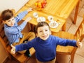 Little cute boys eating dessert on wooden kitchen. home interior. smiling adorable friendship together forever friends Royalty Free Stock Photo
