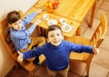 Little cute boys eating dessert on wooden kitchen. home interior. smiling adorable friendship together forever friends Royalty Free Stock Photo