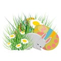 A little cute bunny sleeps near Easter eggs. Easter eggs, grass and daisies.