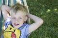 Little cute child blond boy swinging and relaxing on a hammock Royalty Free Stock Photo