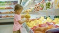 Little cute child girl choosing vegetables in grocery store Royalty Free Stock Photo