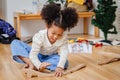 Little cute child girl enjoy playing wood puzzle on the wooden floor at home in living room