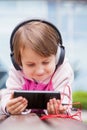 Little cute child girl using mobile phone watching online e-learning video to studying english Royalty Free Stock Photo