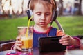 Little cute child girl using mobile phone watching online e-learning video to studying Royalty Free Stock Photo