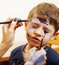 Little cute child making facepaint on birthday party, zombie Apocalypse facepainting, halloween preparing concept Royalty Free Stock Photo