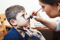 Little cute child making facepaint on birthday party, zombie Apocalypse facepainting, halloween preparing concept Royalty Free Stock Photo