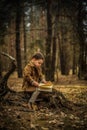 Little cute child is reading in the Forrest