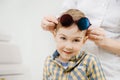 Little cute cunning blonde boy with big blue eyes wearing glasses colored lenses on his forehead. Royalty Free Stock Photo
