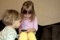 Little cute curious blonde twins watch cartoons on smartphone