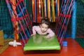 Little cute curly baby girl playing in a children`s entertainment center in the game maze. The child plays in the playground