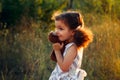 Little cute curly girl hugd a fluffy toy owl. Toddler girl play with sweet doll. A beautiful sunlight, warm colours. Autumn time