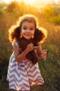 Little cute curly girl hugd a fluffy toy owl. Toddler girl play with sweet doll. A beautiful sunlight, warm colours. Autumn time