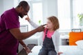 Little cute daughter visiting father at work touching his nose