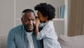 Little cute daughter whispering in dad's ear telling secret mystery says funny joke loving father with kid girl Royalty Free Stock Photo