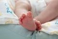 Little cute feet of a newborn baby on a peach plaid. Royalty Free Stock Photo