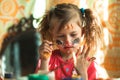 Little cute funny girl artist with paint of the face. Royalty Free Stock Photo