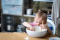 Little cute funny girl licking the dough from her finger helping mother prepare pie cake in kitchen, baking homemade Royalty Free Stock Photo